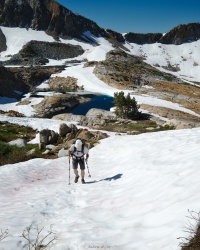 Dad places his feet and trekking poles carefully while climbing the somewhat icy snow slope snow yosemite climb