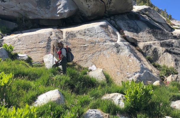 I hike up a grassy ramp to reach a nice granite bench. Photo credit: Amanda sierra high route