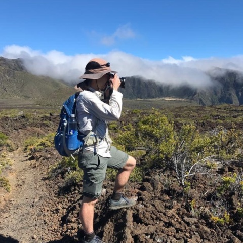 Yours truly perches on some rocks to get a shot of a distant Hawaiian volcano. Photo credit: Brian haleakala hiking photography