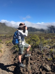 Yours truly perches on some rocks to get a shot of a distant Hawaiian volcano. Photo credit: Brian haleakala hiking photography