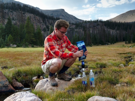 Brian filters water from the small creek feeding Ouray Lake uinta mountains backpacking