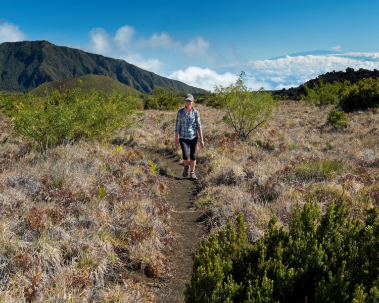 Diane hiking through the lush vegetation in the eastern side of the valley haleakala hiking clouds