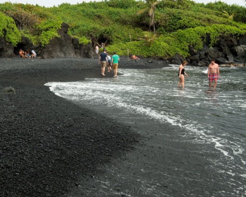 The pounding waves have turned the black volcanic rock into sand and smooth pebbles here wai'anapanapa state park black sand beach