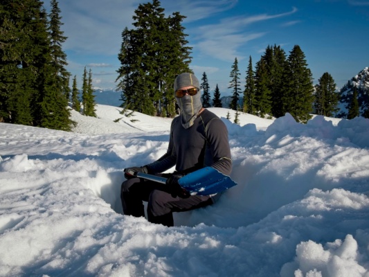 Madhav poses with the shovel, a useful construction tool when camping in the snow! snow camping