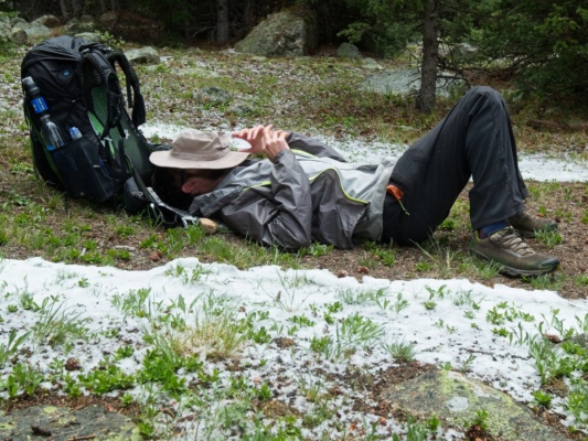Daniel rests on the dry ground where his tarp used to be lost creek wilderness