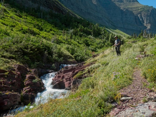 All of the water melting from the glaciers up the valley collects and roars through the red sandstone glacier national park cascade