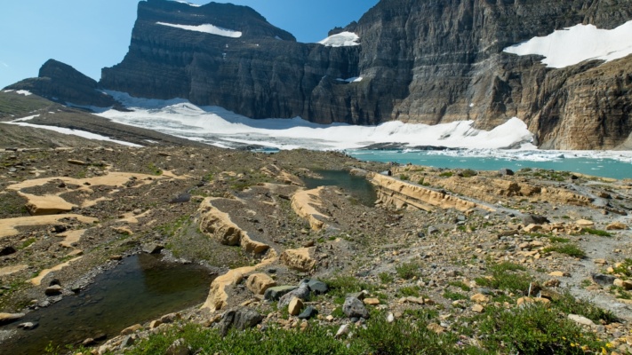 The Grinnell glacier leaves scraped-smooth stone slabs and debris behind as it recedes glacier national park grinnell