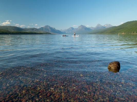 Two paddleboarders enjoying the evening on Lake McDonald mcdonald lake glacier national park