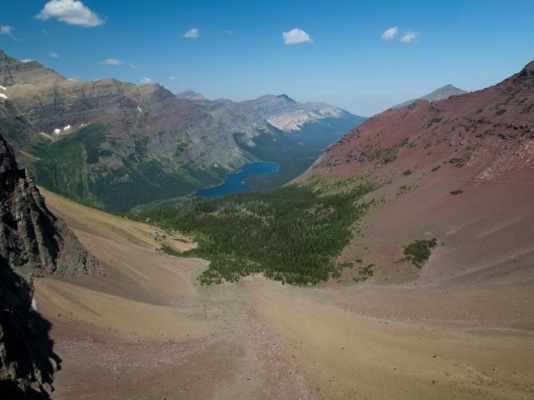 A long, gravel bowl leads to a forested cirque and, in the next valley down, Elizabeth Lake glacier national park