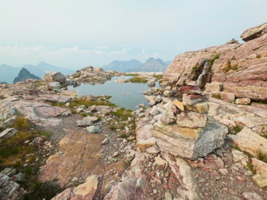 The undulating, rocky landscape is interspersed with little pools full of glacial meltwater glacier national park