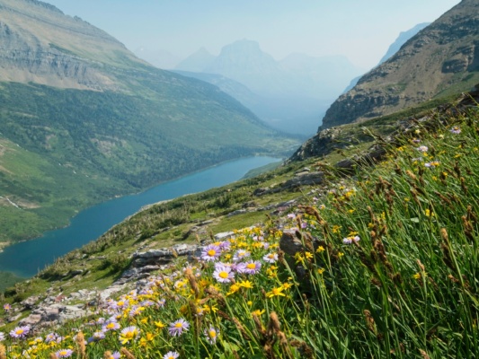 A thick haze from distant wildfires obscures the distant peaks glacier national park gunsight lake