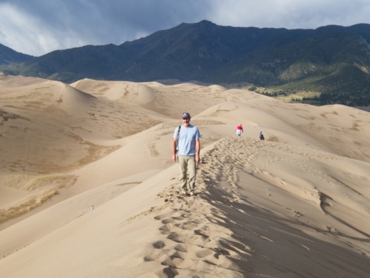 Steve walking along the ridge of a sand dune