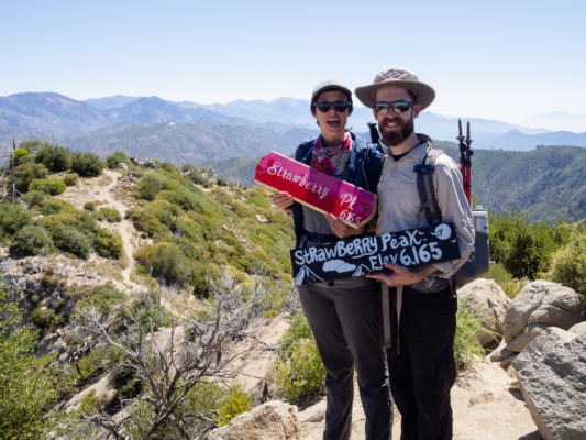 Kate and Daniel pose with two of the summit signs strawberry peak summit