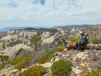 Diane holds on to her hat to avoid losing it in the fierce wind zion national park west rim
