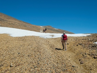Alex striding up a switchback near the summit white mountain peak