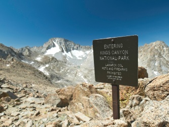 A sign at Lamarck Col marking the Kings Canyon boundary; Mount Darwin towers in the background kings canyon boundary