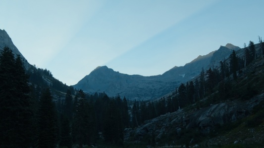 Sun rays stream through the peaks long before they reach the valleys below sierra nevada mountains