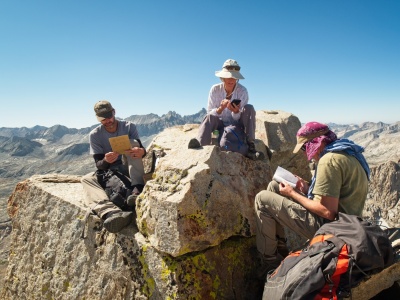 Craig, Kathy, and Daryn reading the old summit registers on Triple Divide Peak triple divide peak