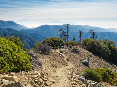 The trail winds along the exposed ridge overlooking the marine layer iron mountain