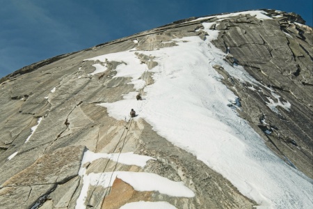 Two climbers free-soloing a patch of ice between exposed sections of the cables half dome