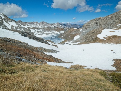 Descending toward Red and White Lake across a diverse mix of slate, grass, and snow red and white lake