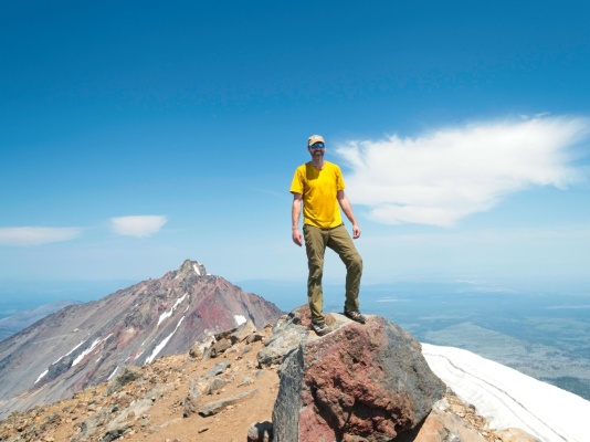 Craig poses on the highest point of Middle Sister middle sister summit