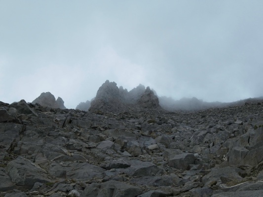 Clouds drift across the spires, obscuring the summit temple crag spires