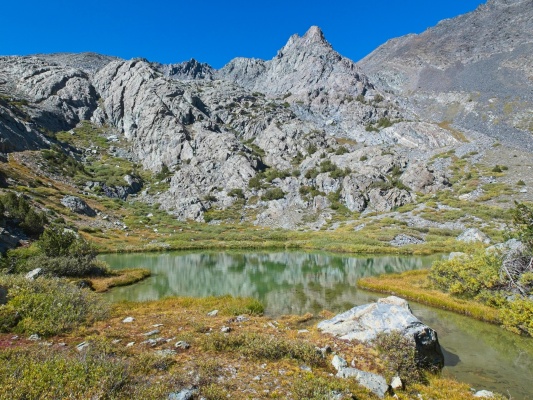 A pristine pond below the cliff bands alpine pond