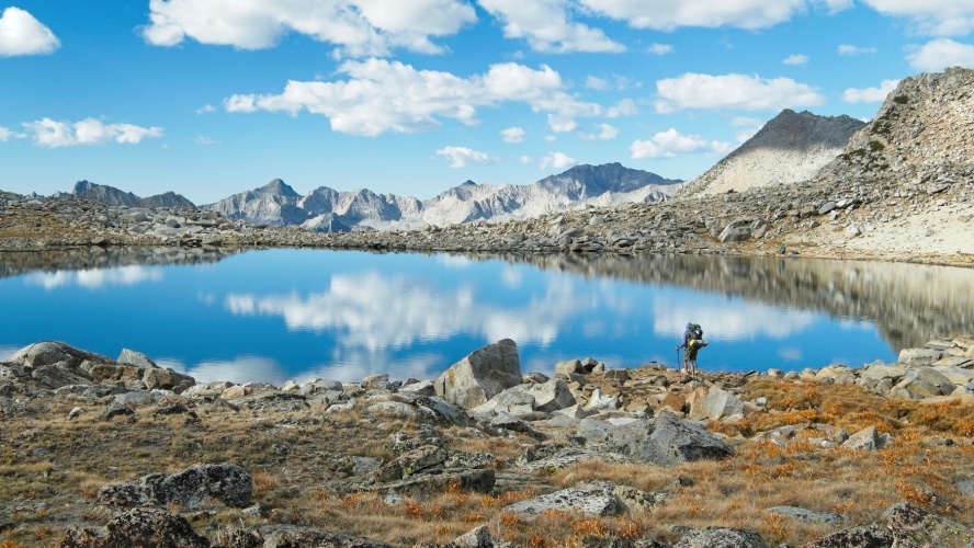 Alex scopes out a spot for a break on the shore of a lake near Bishop Pass bishop pass lake