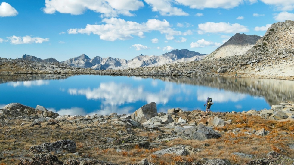 Alex scopes out a spot for a break on the shore of a lake near Bishop Pass bishop pass lake