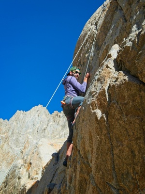 Alex climbs up the wall rock climbing
