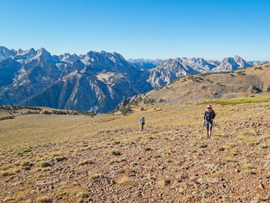 Dagmar and Andrew walk up the slope toward Eagle Peak with a spectacular view behind them eagle peak views