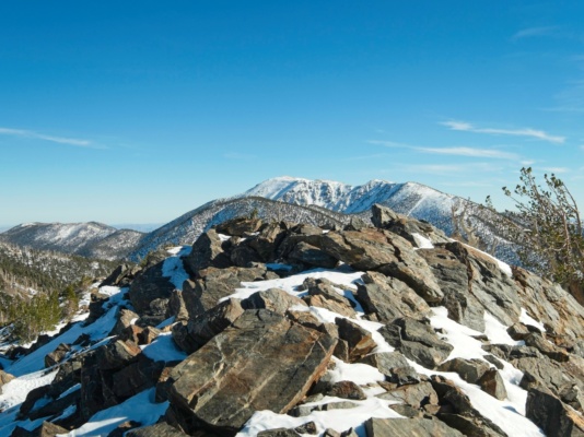 I hop across the rocks and avoid stepping on the ice in between shields peak summit