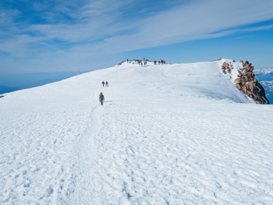 Josh and Jack hike toward me on the summit plateau mount shasta mountaineering