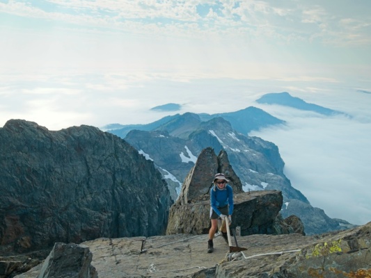 Dagmar scrambles up the final slab to the lookout as clouds close in below us three fingers lookout