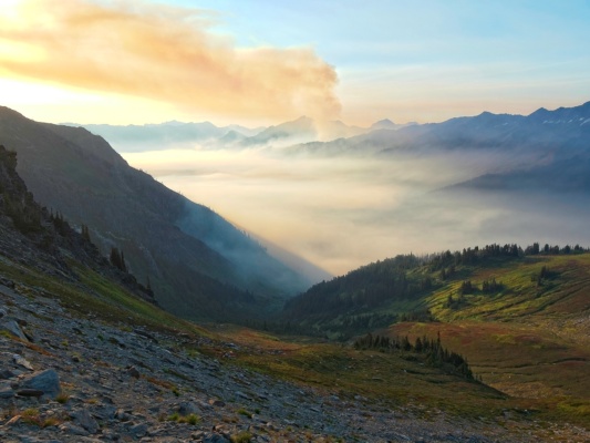 A plume of smoke rises from the nearby wildfire wildfire