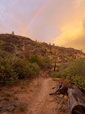The light afternoon drizzle creates a rainbow above the trail rainbow