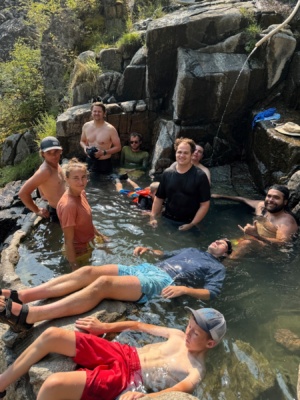 Our group enjoys a hot spring; clockwise, beginning at 6:00 - Ryker, Isaac, Olivia, Gabe, Christopher, Brian, Mason, Noah, and Aaron main salmon river rafting