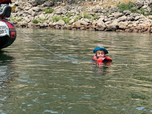Theo floats behind the raft main salmon river rafting