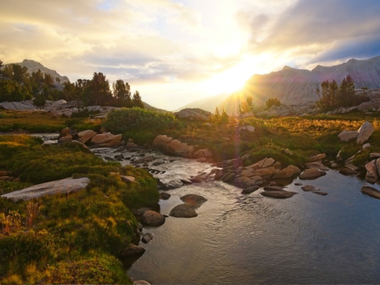 The sun streams in under the clouds sunrise