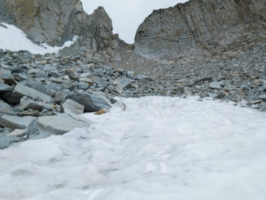 I'm able to glissade down a lingering snowfield below the chute seven gables