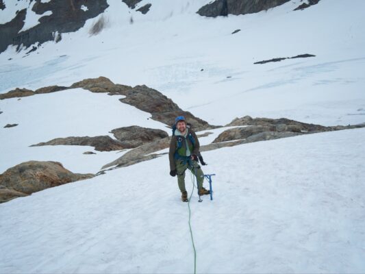 Cody with the lower glacier behind him mountaineering
