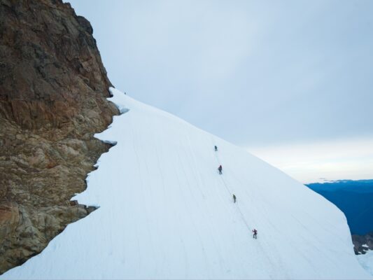 The five-person team climbs up the steep slope to the summit block mount olympus