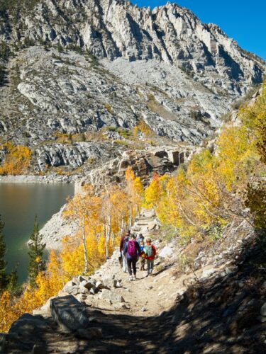 A family hikes down the trail by South Lake south lake autumn